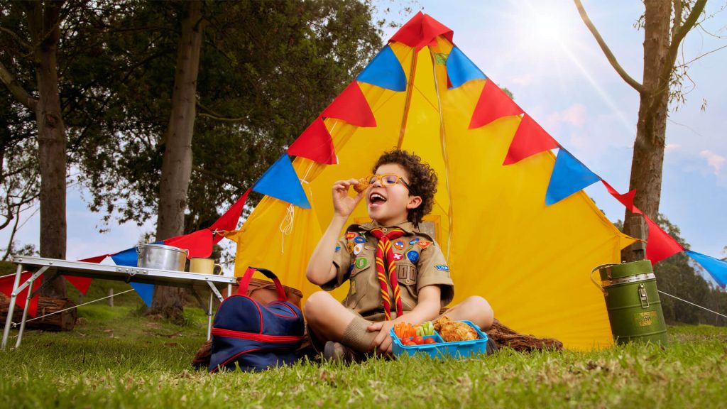 Niño scout disfrutando una merienda saludable con Pollo Norteño.