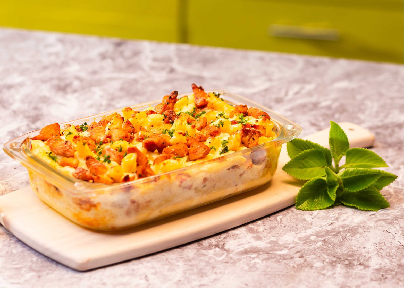 Molde de pasta alfredo al horno sobre mesa de cocina