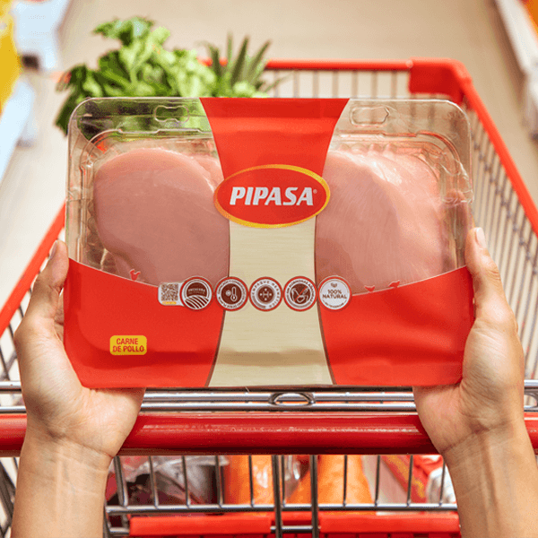 Bandeja de Pechuga Pipasa Manos de mujer en el carrito del supermercado con una bandeja de pechugas de Pollo Pipasa.